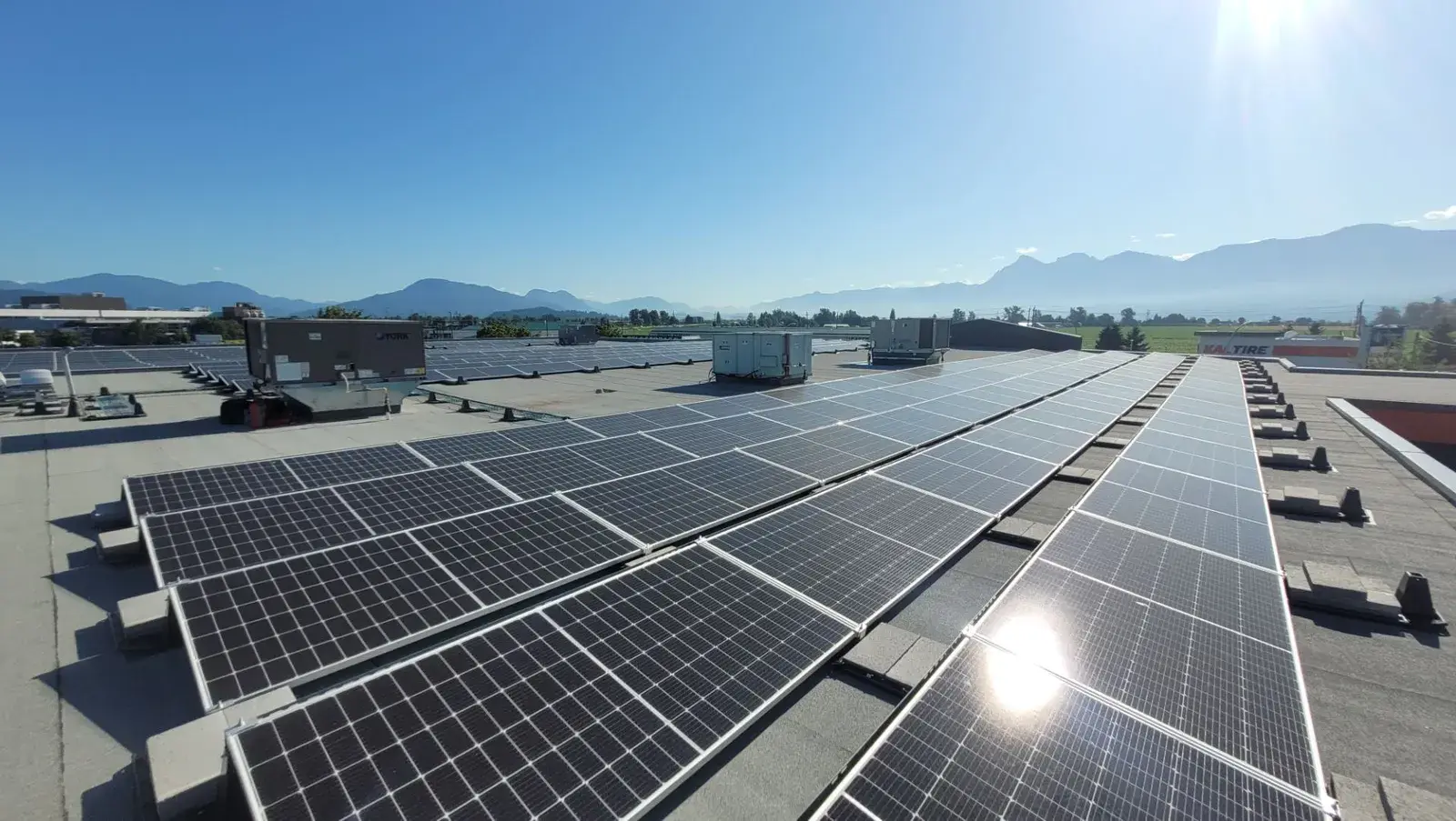 Rooftop solar panels at Mark's Chilliwack with the Fraser Valley mountains behind