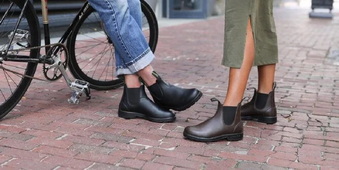 2 women wearing blundstone boots on foot in city
